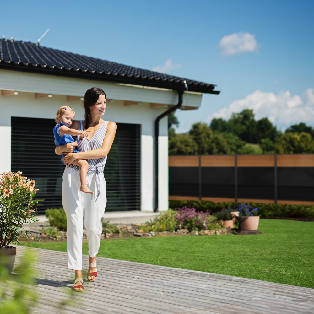 falagotti Eleganza Solarzaun – stilvoller Sichtschutz mit integrierter Photovoltaik falagotti Solarzaun Eleganza im Garten mit Familie und WPC-Elementen in Teak